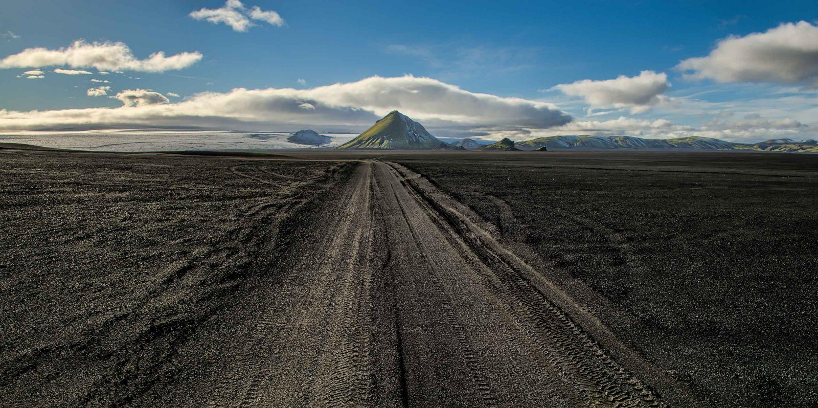 Dirt road approaching a mountain